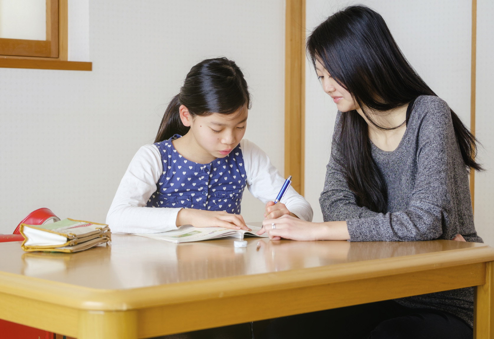 A young student works with her Austin math tutor on an assignment