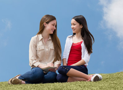 Two Girls Sitting on Grassy Hill Two Girls Sitting on Grassy Hill