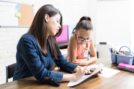 woman providing math tutoring to young girl