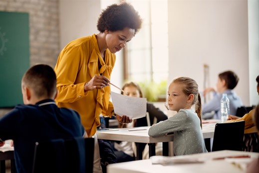 young girl looking at test results with teacher