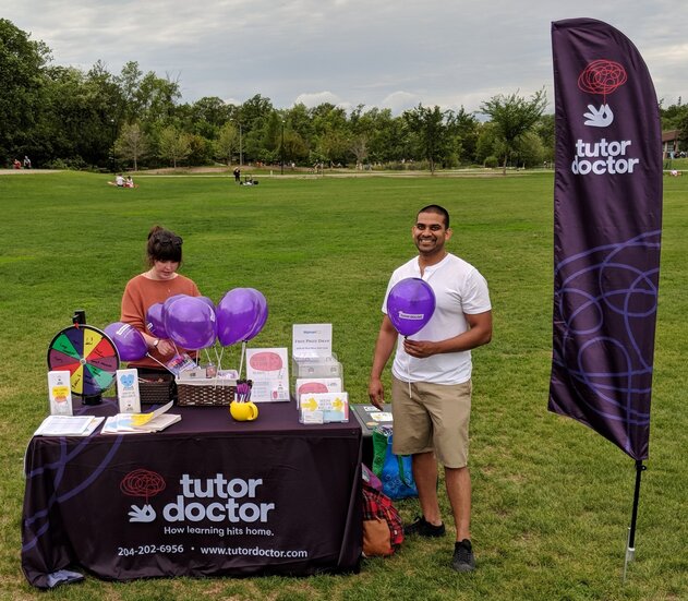 Man and women setting up Tutor Doctor event table