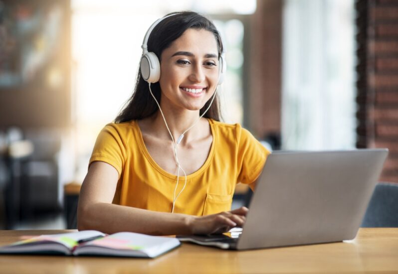 young woman sitting at desk and using laptop