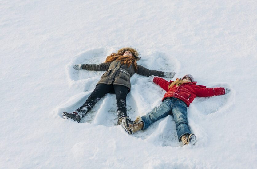 Two girls making snow angels