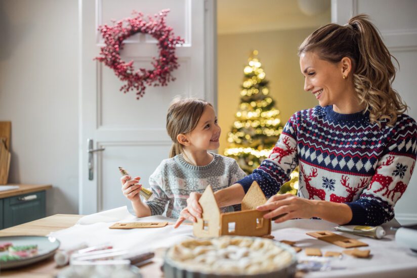 Parent and child making gingerbread house