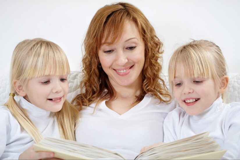 A mother reads to her two daughters