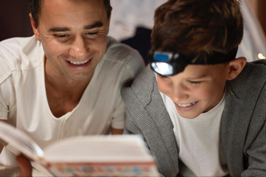 A father and son read a book together