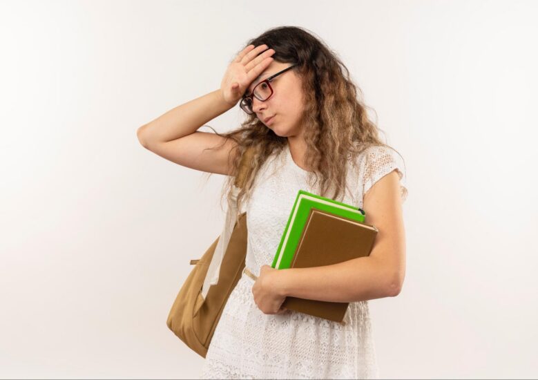 Student holds books while struggling with reading