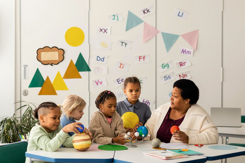 Teacher sits with students in classroom to practice reading activities